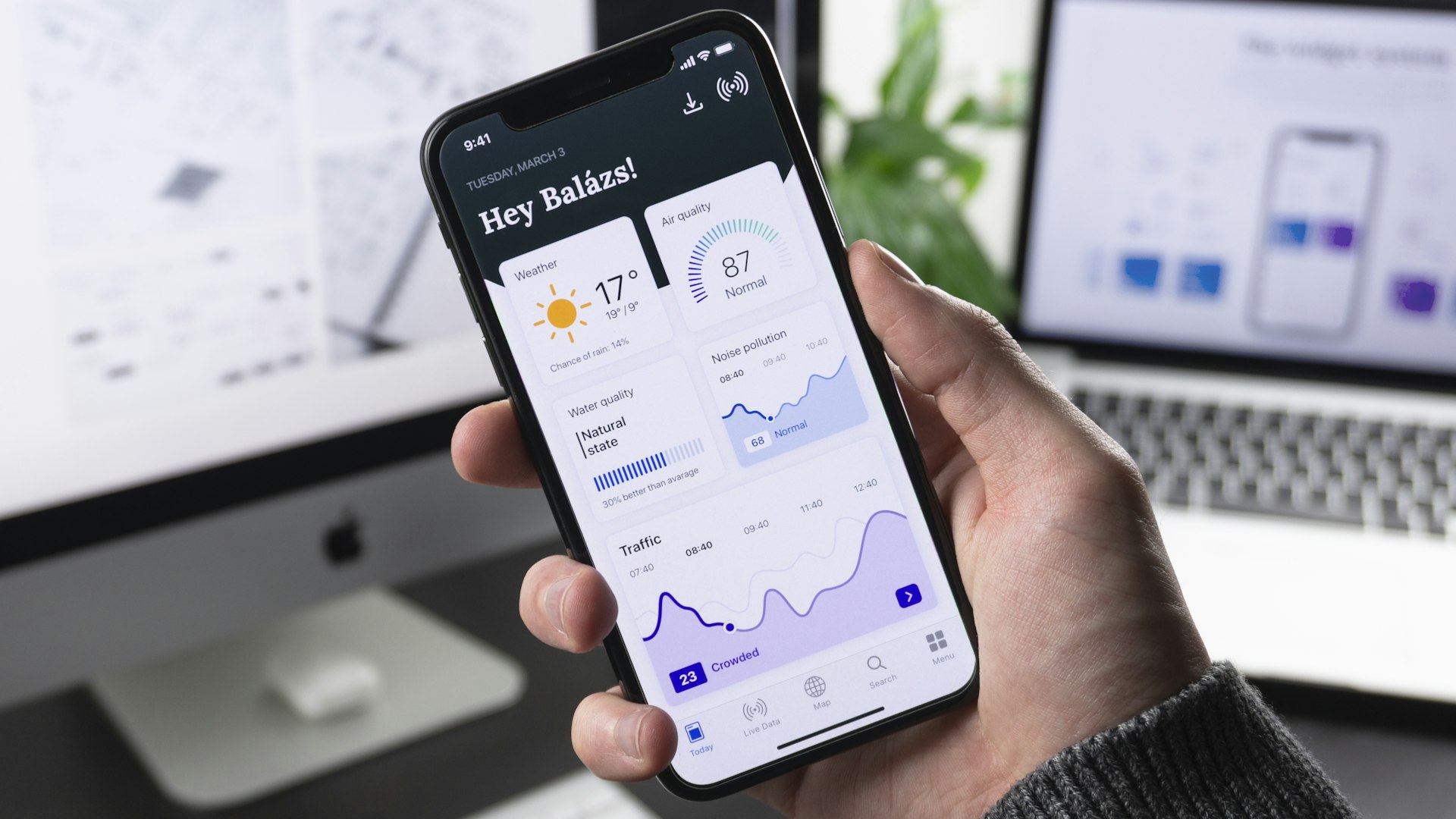Custom mobile app dashboard on a smartphone with development screens in the background representing software and mobile app development
